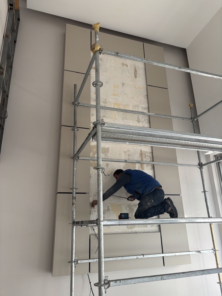 Çayırlı İş Merkezi yüksek lobi duvarında modüler panel montajı yapan uygulama ekibi